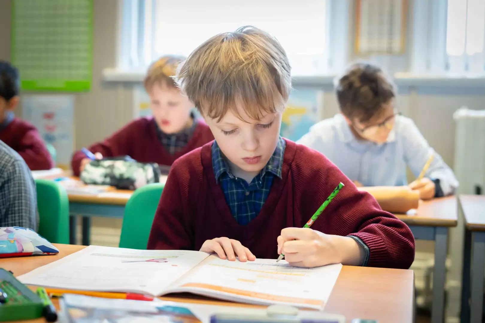 A Year 3 boy concentrating on his work during a lesson